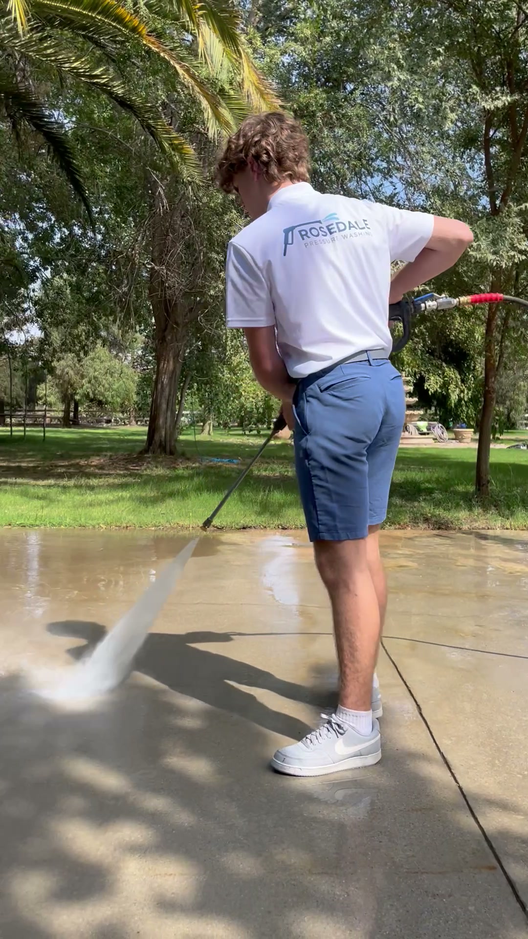 Rosedale Pressure Washing branded shirt while cleaning concrete