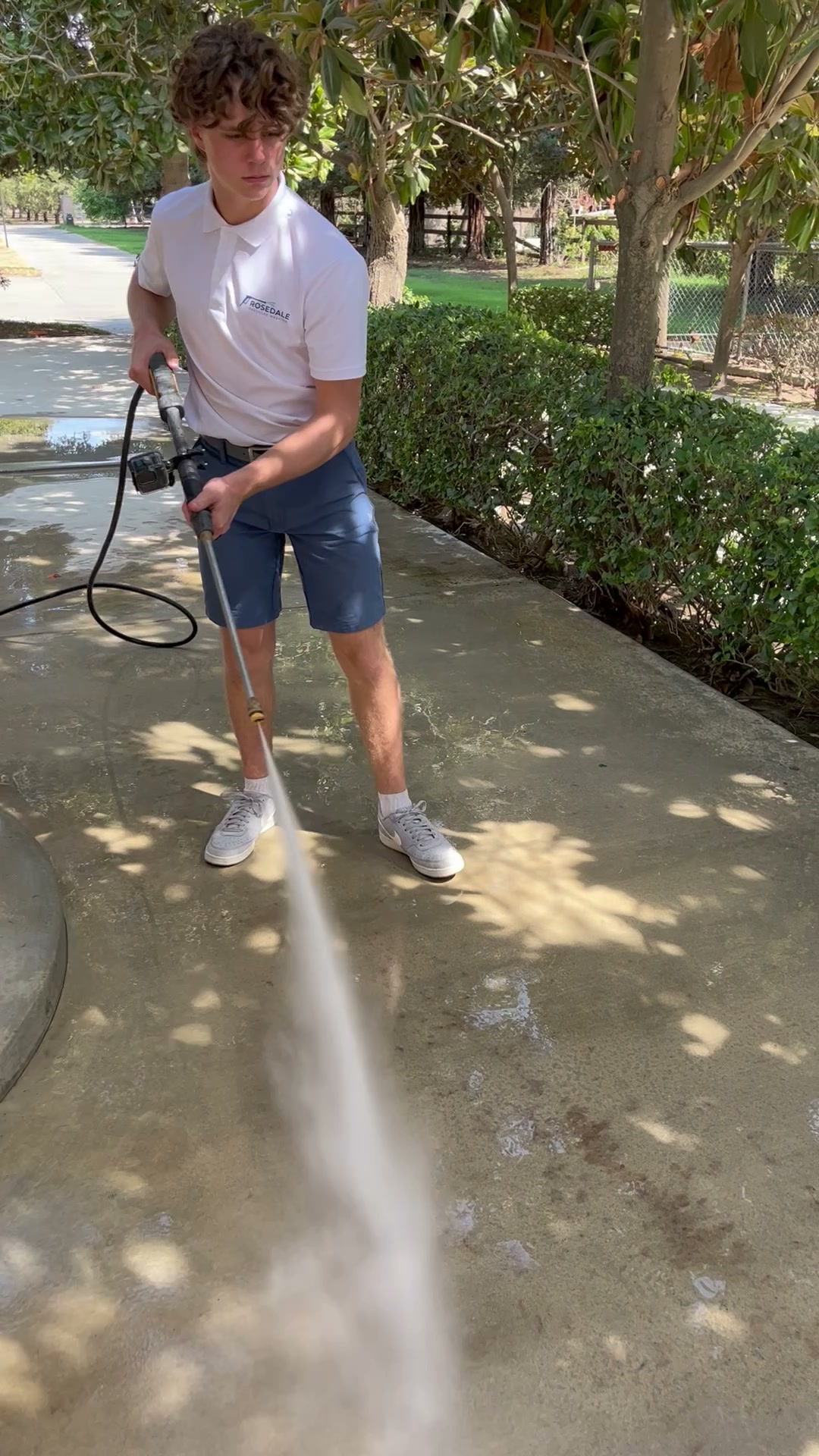 Liam pressure washing a residential concrete walkway