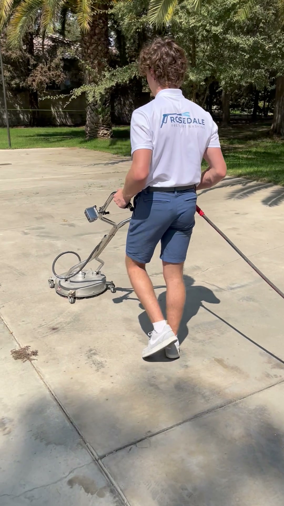 Professional surface-cleaning equipment in use on a driveway